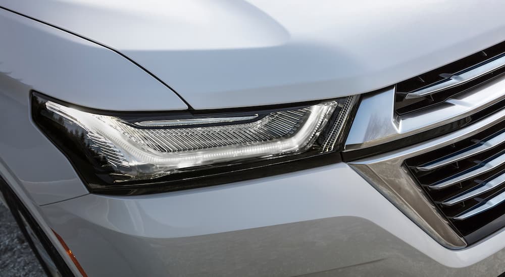 A close up shows the passanger headlight on a white 2022 Chevy Traverse Premium.