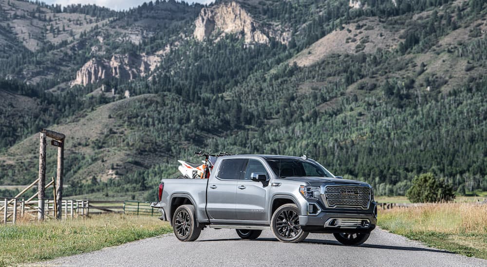 A grey 2021 GMC Sierra 1500 Denali CarbonPro is shown with a dirt bike in the bed.