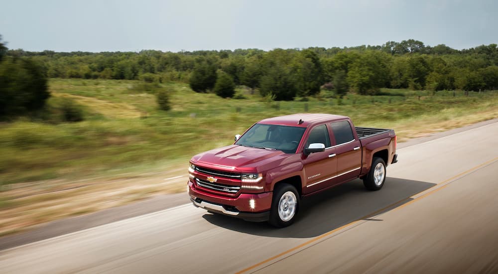 A maroon 2017 Chevy Silverado LTZ Z71 is shown driving down a road after visiting a used car dealer near you.