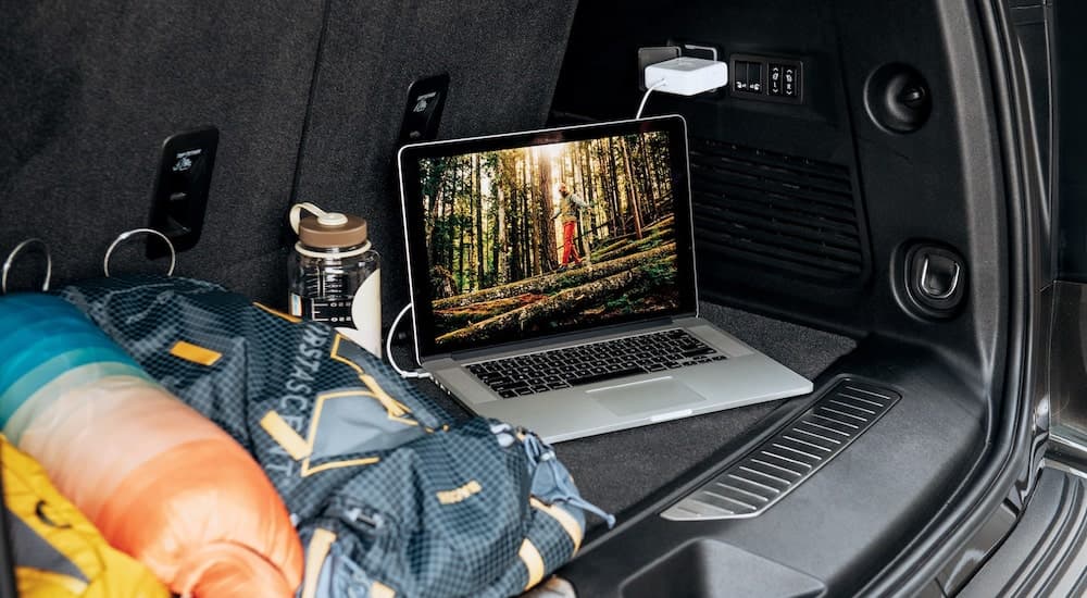 A laptop and hiking gear is shown in the trunk of a 2021 Chevy Tahoe High Country.