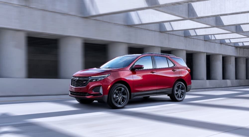 A red 2022 Chevy Equinox RS is shown driving after leaving a Miami, OK Chevy dealer.