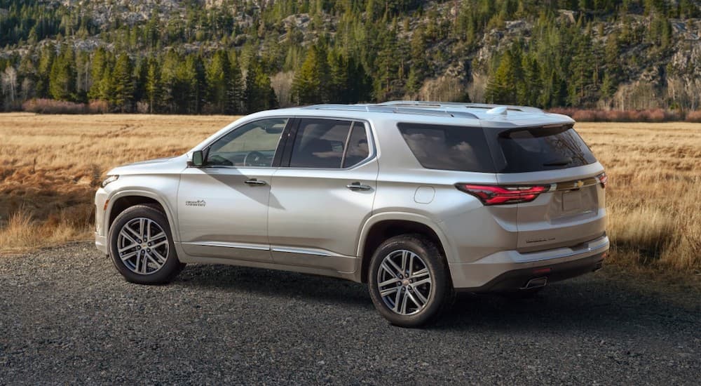 A white 2022 Chevy Traverse is shown parked next to a grassy field.